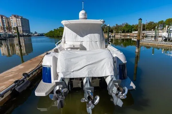 Slide: The Image of 2023 Intrepid 438 Evolution boat docked with covered engines in a marina. - 3