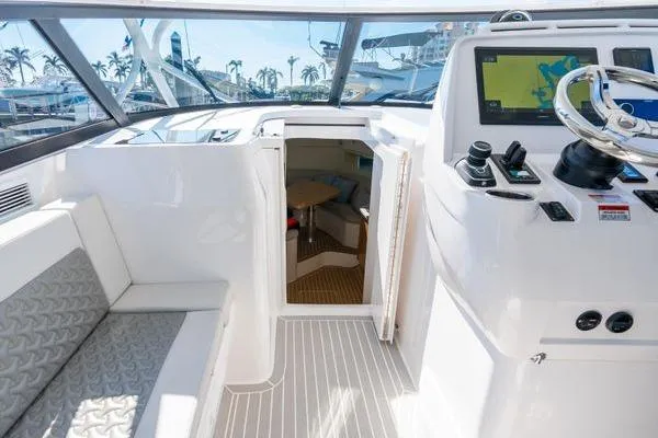 Slide: The Image of 2023 Intrepid 438 Evolution yacht cockpit with helm, seating, and cabin entrance. - 30