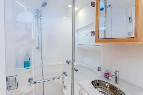 Slide: The Image of 2023 Intrepid 438 Evolution yacht bathroom with modern shower and sink. - 32