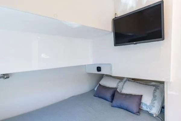 Slide: The Image of 2023 Intrepid 438 Evolution cabin with bed, pillows, and wall-mounted TV. - 43