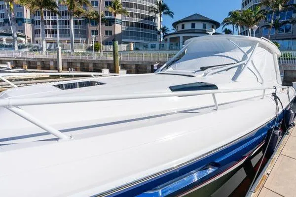 Slide: The Image of 2023 Intrepid 438 Evolution yacht docked near modern buildings and palm trees. - 7