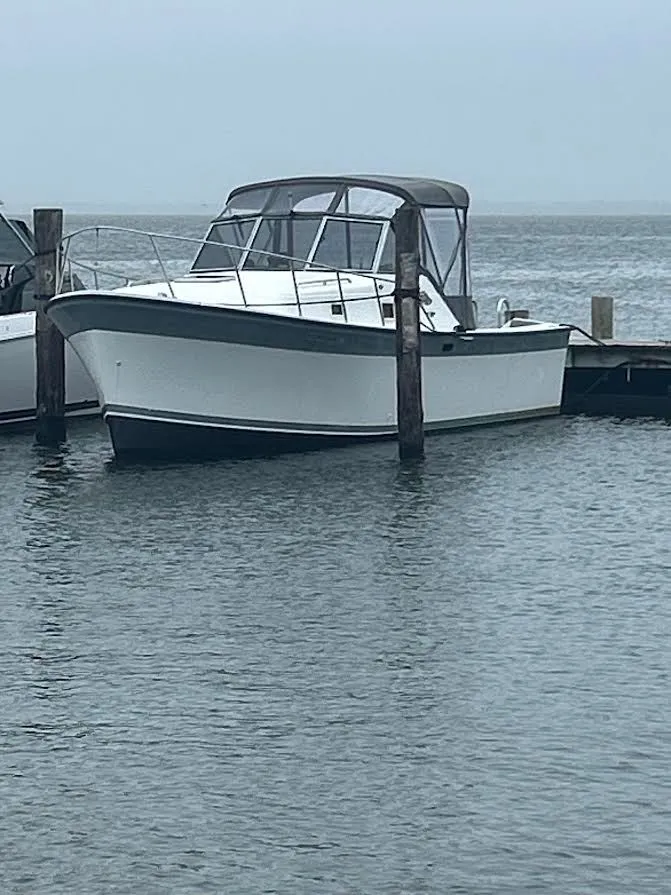 The Image of 1986 Luhrs Alura boat docked with American flag. - 0