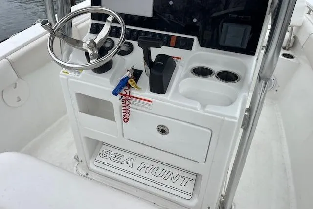 Slide: The Image of 2018 Sea Hunt Ultra 211 boat console with steering wheel and controls. - 13