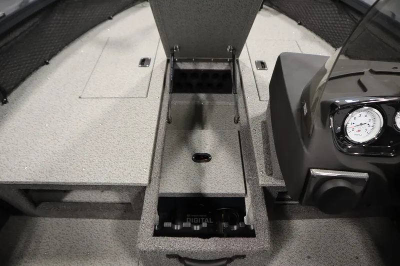 Slide: The Image of 2024 Crestliner 1750 Hawk interior with open storage compartment and dashboard gauges. - 19