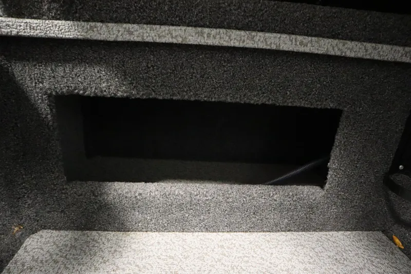 Slide: The Image of 2024 Crestliner 1750 Hawk interior storage compartment with gray carpeted finish. - 31