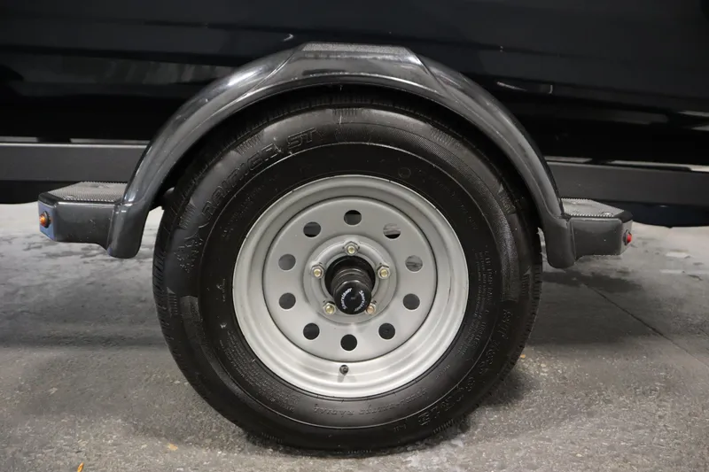 Slide: The Image of 2024 Crestliner 1750 Hawk trailer wheel with black tire and metal rim. - 46