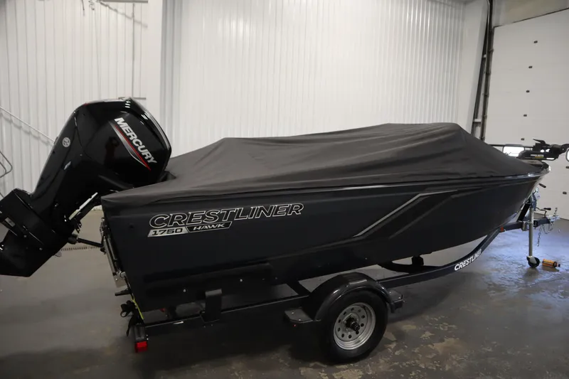 Slide: The Image of 2024 Crestliner 1750 Hawk boat with cover and Mercury outboard motor in a garage. - 47