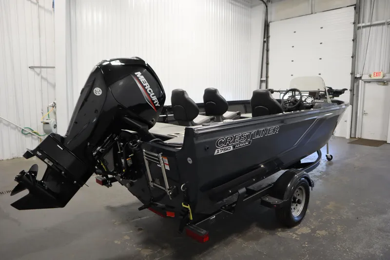 Slide: The Image of 2024 Crestliner 1750 Hawk boat with Mercury engine in a garage setting. - 5