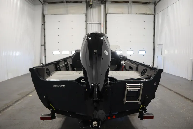 Slide: The Image of 2024 Crestliner 1750 Hawk boat in a garage, rear view with motor visible. - 6