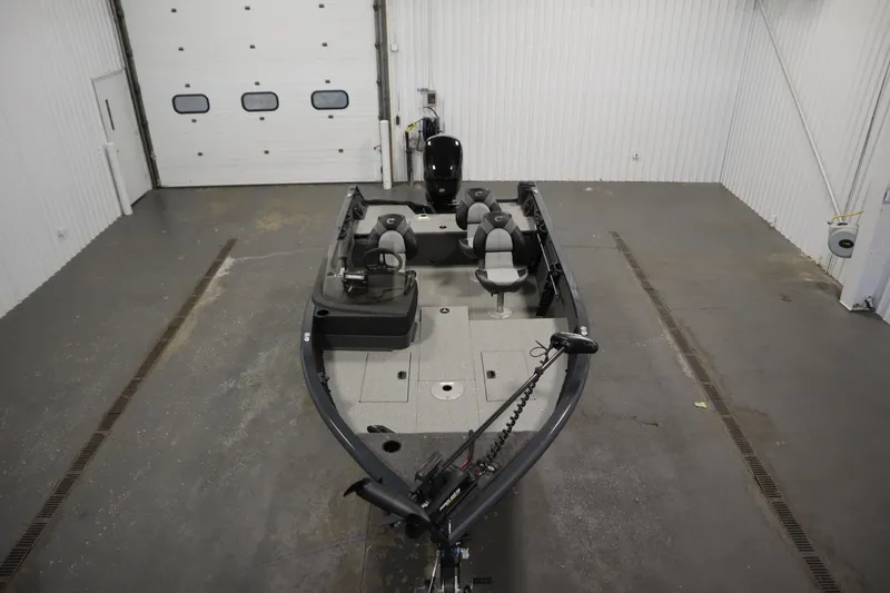 Slide: The Image of 2024 Crestliner 1750 Hawk boat in a spacious indoor garage setting. - 9