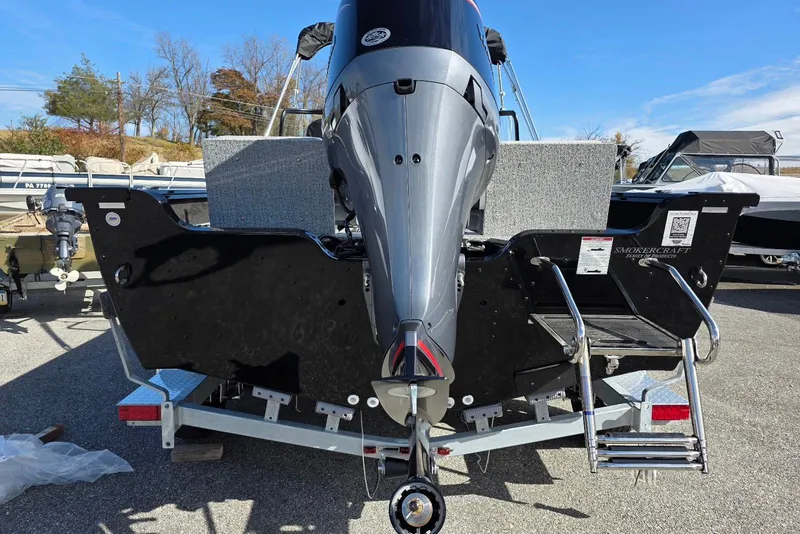 Slide: The Image of 2026 Smoker Craft Adventurer 188 DC boat on trailer, rear view with motor and ladder. - 11