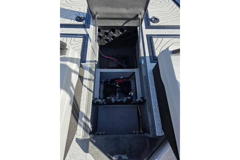 Slide: The Image of 2026 Smoker Craft Adventurer 188 DC boat interior storage compartment with wiring and cup holders. - 18