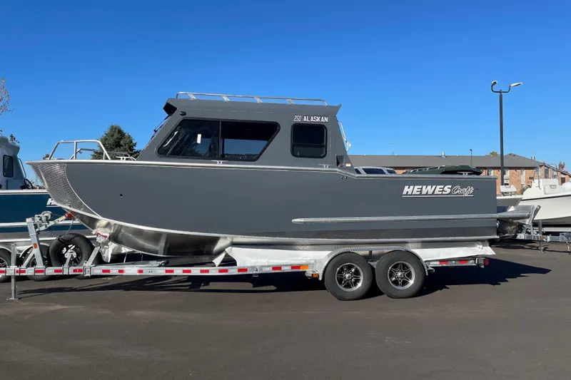 The Image of 2026 Hewescraft 250 Alaskan ET HT boat on trailer, parked outdoors. - 0