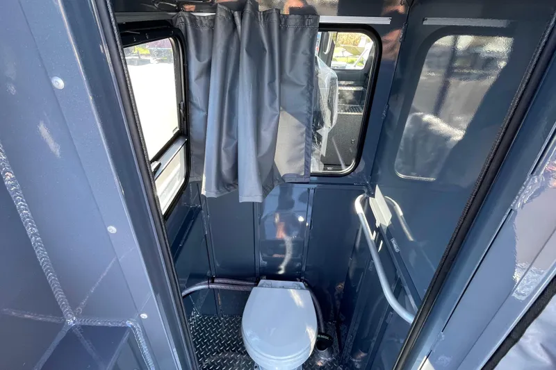 Slide: The Image of 2026 Hewescraft 250 Alaskan ET HT boat interior with compact bathroom and window. - 10