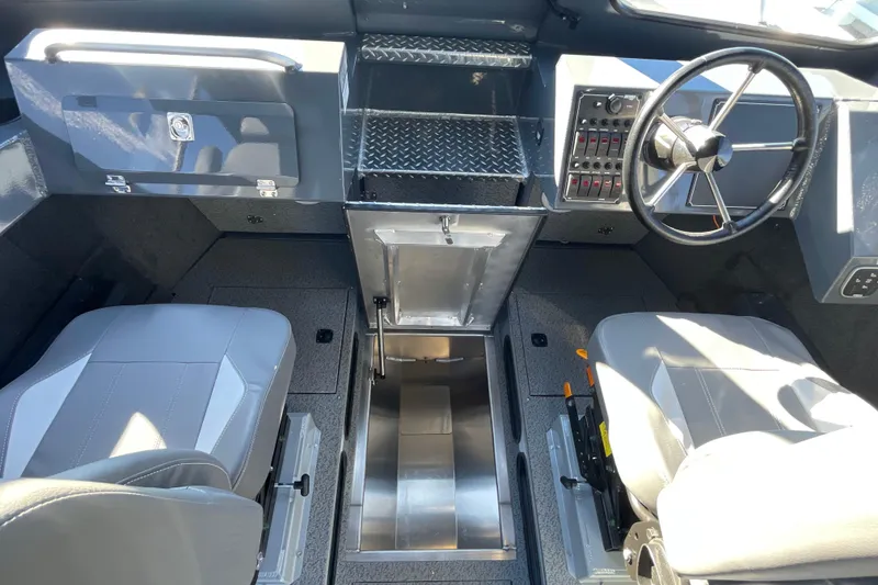 Slide: The Image of Interior of 2026 Hewescraft 250 Alaskan ET HT boat, featuring steering wheel and seating. - 28