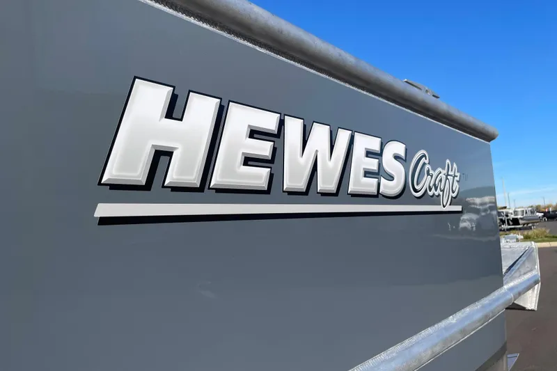 Slide: The Image of 2026 Hewescraft 250 Alaskan ET HT boat logo on gray surface under blue sky. - 32