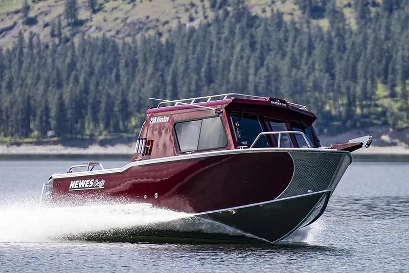 Slide: The Image of 2026 Hewescraft 250 Alaskan ET HT boat cruising on a scenic lake. - 36