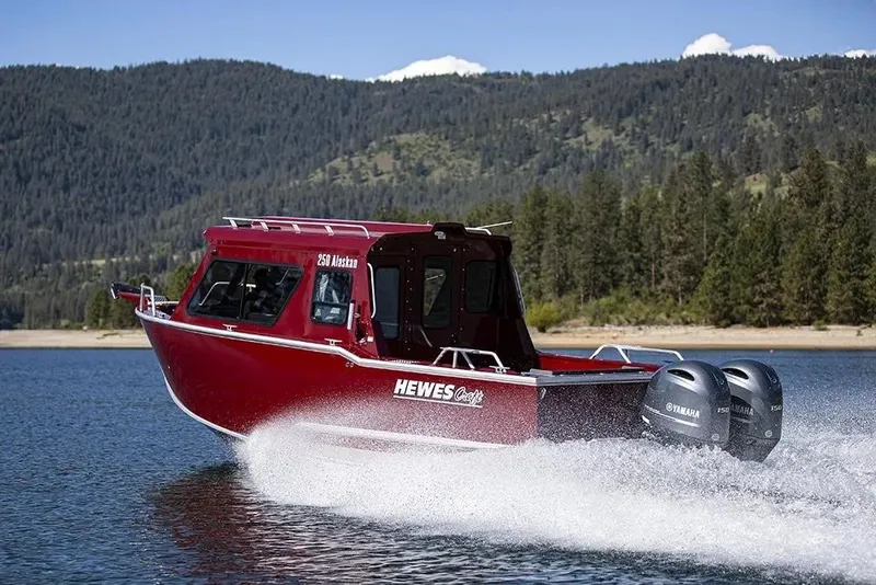 Slide: The Image of 2026 Hewescraft 250 Alaskan ET HT boat cruising on a scenic lake. - 37