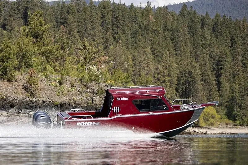 Slide: The Image of 2026 Hewescraft 250 Alaskan ET HT boat cruising on a scenic lake. - 38