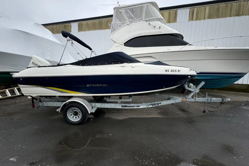 The Image of 2017 Stingray 204 LR boat on trailer, parked outdoors. - 1