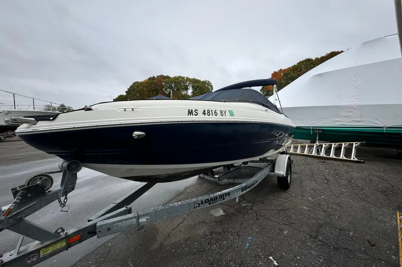 Slide: The Image of 2017 Stingray 204 LR boat on trailer, parked outdoors on a cloudy day. - 3