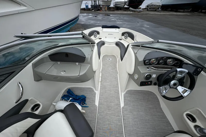 Slide: The Image of 2017 Stingray 204 LR boat interior with steering wheel and seating area. - 4