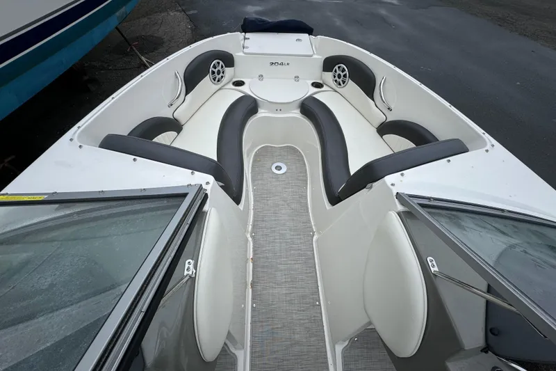 Slide: The Image of 2017 Stingray 204 LR boat interior with cushioned seating and speakers. - 5