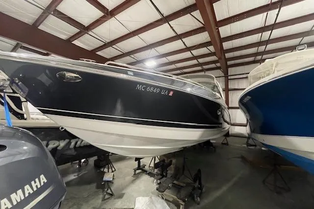 Slide: The Image of 2017 Formula 350 Crossover Bowrider in storage, black and white hull, indoor facility. - 1