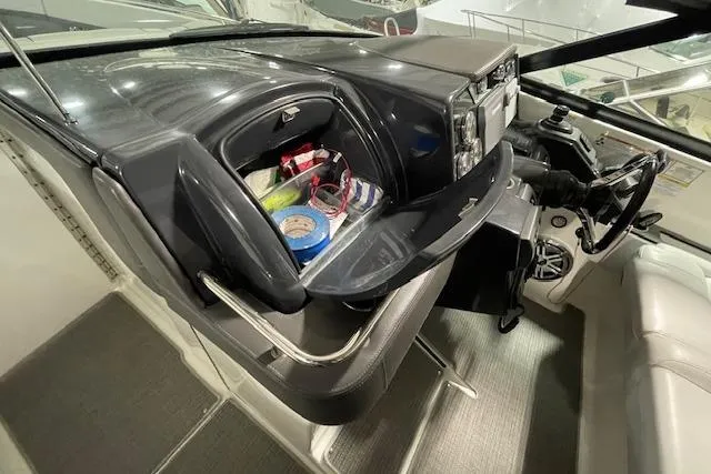 Slide: The Image of 2017 Formula 350 Crossover Bowrider dashboard with open storage compartment, showcasing various items. - 44