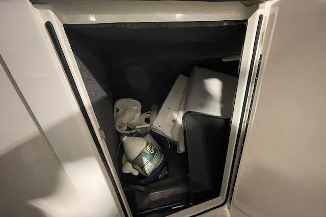 Slide: The Image of Storage compartment in 2017 Formula 350 Crossover Bowrider with various items inside. - 58