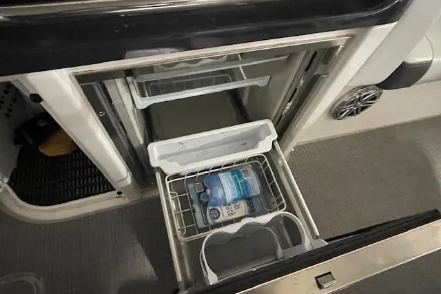 Slide: The Image of 2017 Formula 350 Crossover Bowrider interior fridge with open drawers and stored items. - 60