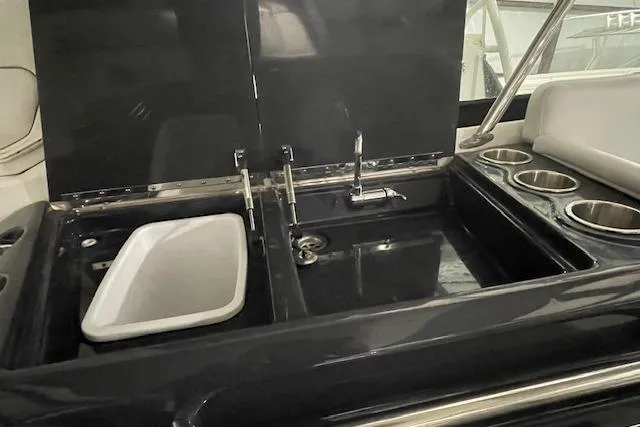 Slide: The Image of 2017 Formula 350 Crossover Bowrider boat kitchen area with sink and cup holders. - 63
