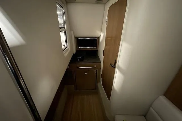 Slide: The Image of 2017 Formula 350 Crossover Bowrider interior cabin with kitchenette and window. - 65
