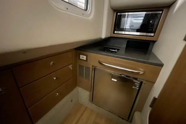 Slide: The Image of 2017 Formula 350 Crossover Bowrider interior kitchen with microwave and storage cabinets. - 66