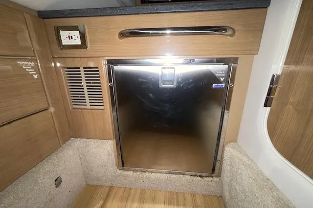 Slide: The Image of 2017 Formula 350 Crossover Bowrider interior with stainless steel fridge and wooden cabinetry. - 68