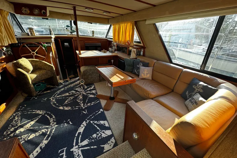 Slide: The Image of 1986 Carver 42 Aft Cabin Motor Yacht interior with helm, controls, and wooden cabinetry. - 61