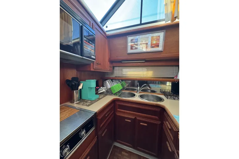 Slide: The Image of Master ensuite head , off of the v-berth 1986 Carver 42 Aft Cabin Motor Yacht bathroom with sink, toilet, and wooden cabinetry. - 85