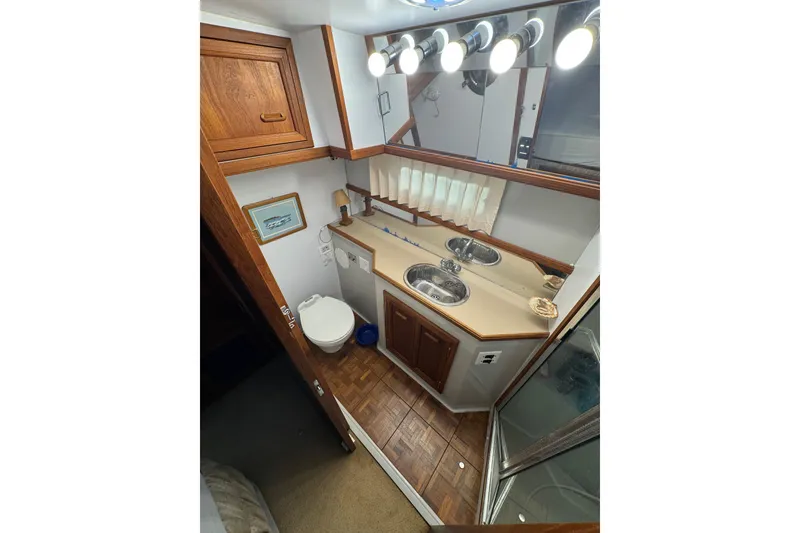Slide: The Image of 1986 Carver 42 Aft Cabin Motor Yacht bathroom with toilet and wooden accents. - 108