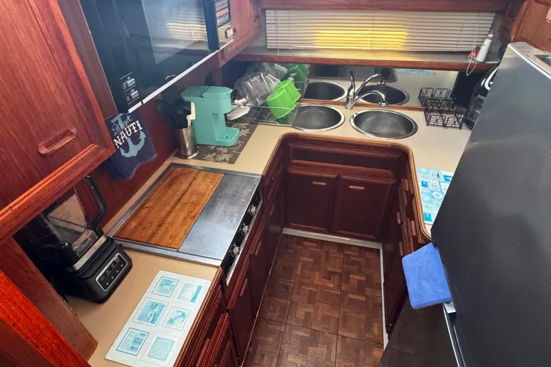 Slide: The Image of Galley 1986 Carver 42 Aft Cabin Motor Yacht kitchen with wooden cabinets and stainless steel appliances. - 77