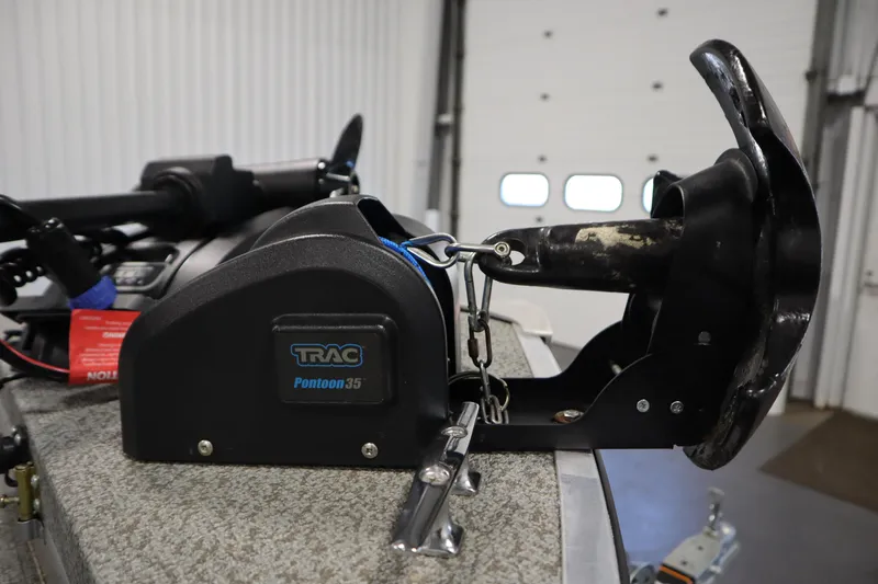 Slide: The Image of 2024 Starcraft Patriot 14 TL with TRAC Pontoon 35 anchor system in a garage. - 14