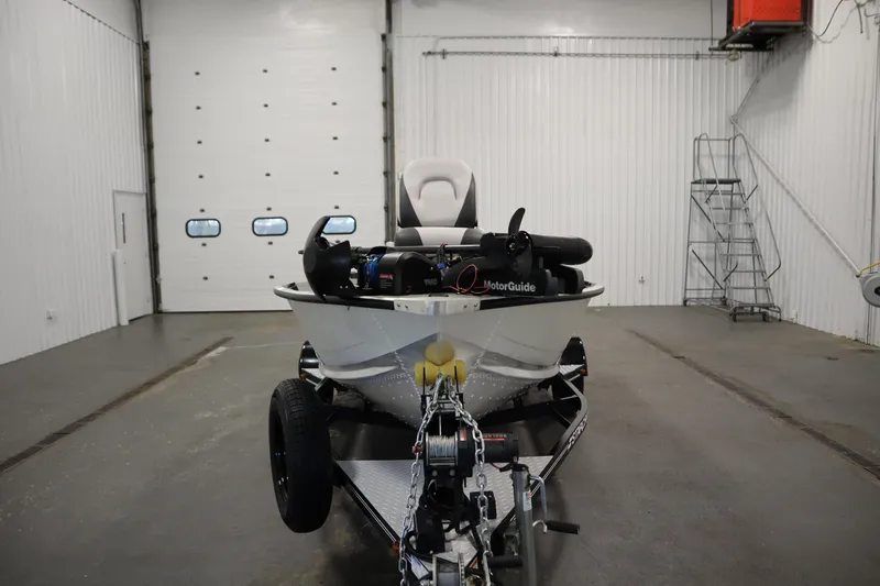 Slide: The Image of 2024 Starcraft Patriot 14 TL boat in a garage, featuring a MotorGuide trolling motor. - 2