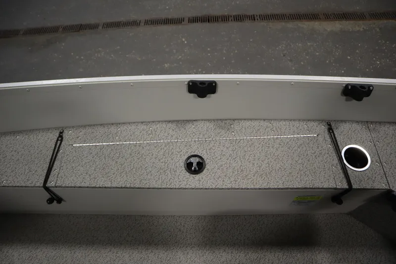 Slide: The Image of 2024 Starcraft Patriot 14 TL boat interior with storage compartment and cup holder. - 23