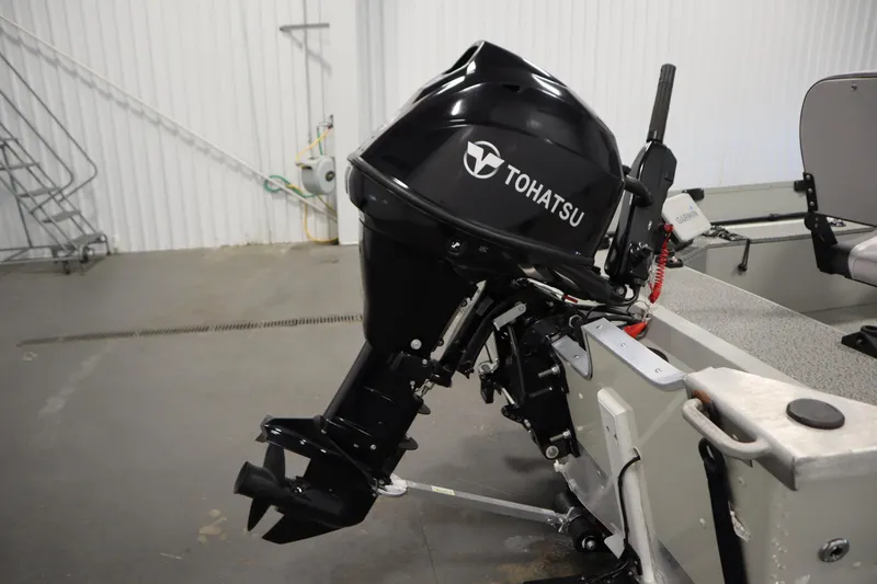 Slide: The Image of 2024 Starcraft Patriot 14 TL with Tohatsu outboard motor in a garage setting. - 35