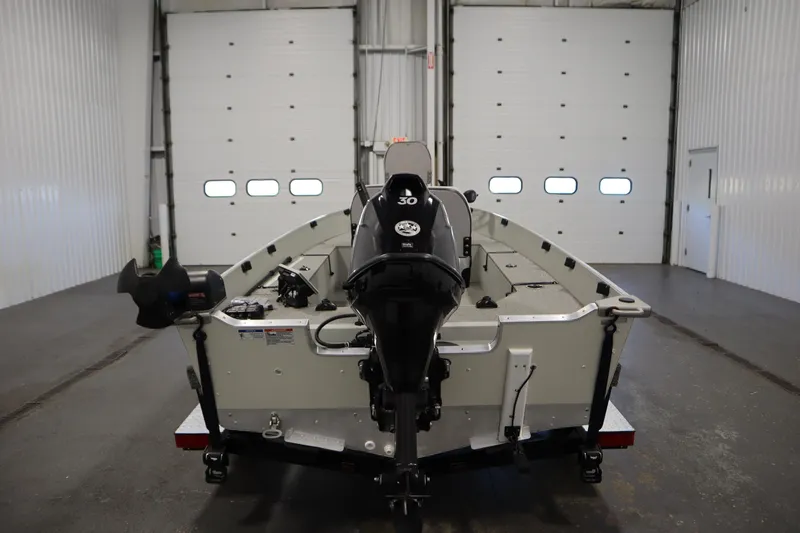 Slide: The Image of 2024 Starcraft Patriot 14 TL boat in a garage, rear view with motor. - 6