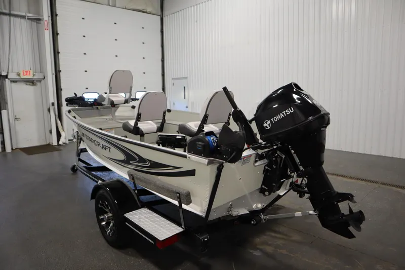 Slide: The Image of 2024 Starcraft Patriot 14 TL boat with Tohatsu motor in a garage setting. - 7
