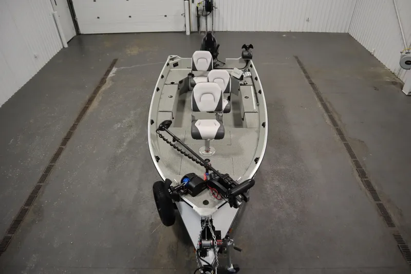 Slide: The Image of 2024 Starcraft Patriot 14 TL boat in a garage, featuring seating and equipment. - 9