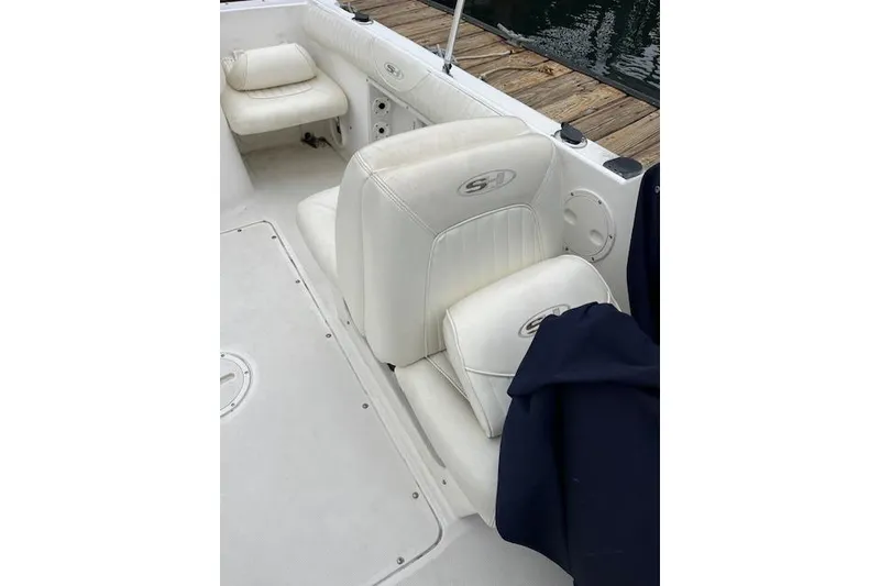 Slide: The Image of 2007 Sea Hunt Escape 220 boat interior with white seating and dock view. - 10
