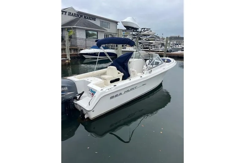 Slide: The Image of 2007 Sea Hunt Escape 220 boat docked at a marina with Yamaha outboard motor. - 2