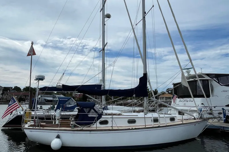 Slide: The Image of 1981 Cape Dory 30 sailboat docked in a marina, featuring classic design and American flag. - 10