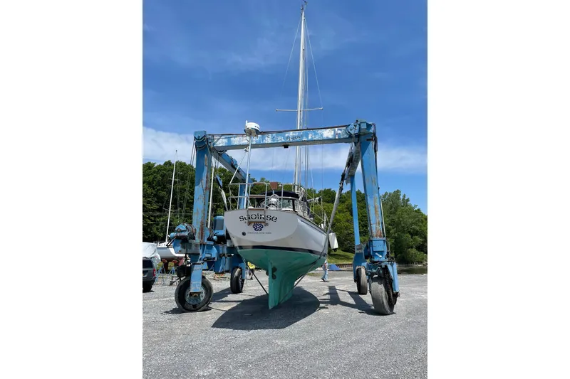 Slide: The Image of 1981 Cape Dory 30 sailboat on a lift, clear sky background. - 3